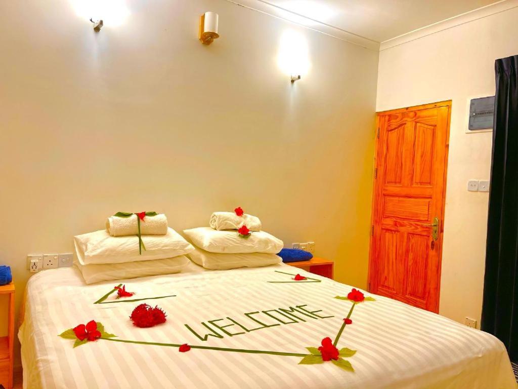 图杜Sunny Side Inn Thoddoo的一间卧室,床上放着鲜花