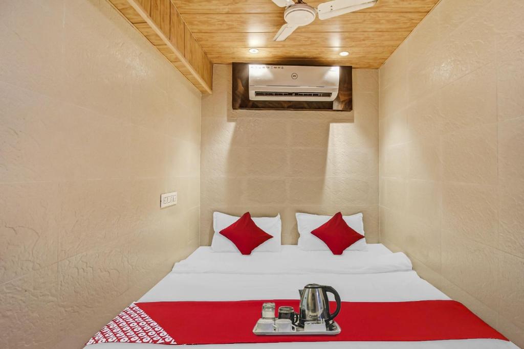 卡延OYO K K Royal Residency的小房间设有一张带红色枕头的床