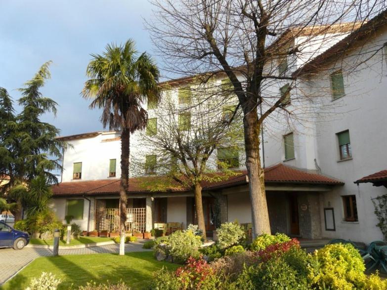 托里塔迪谢纳Hotel La Piccola Stazione的一座白色的大建筑,前面有棕榈树