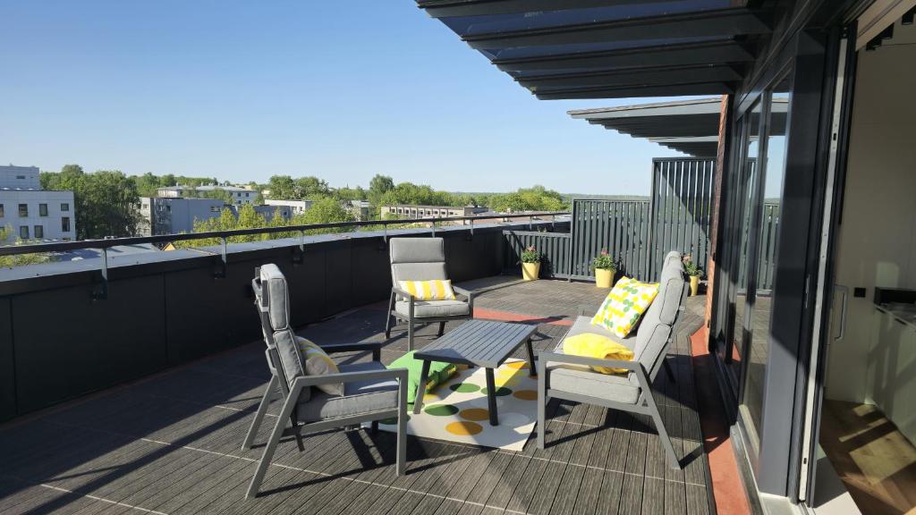 塔尔图Artisa Riia Str 22 Luxury Penthouse Apartment - 8th fl的阳台的天井配有桌椅