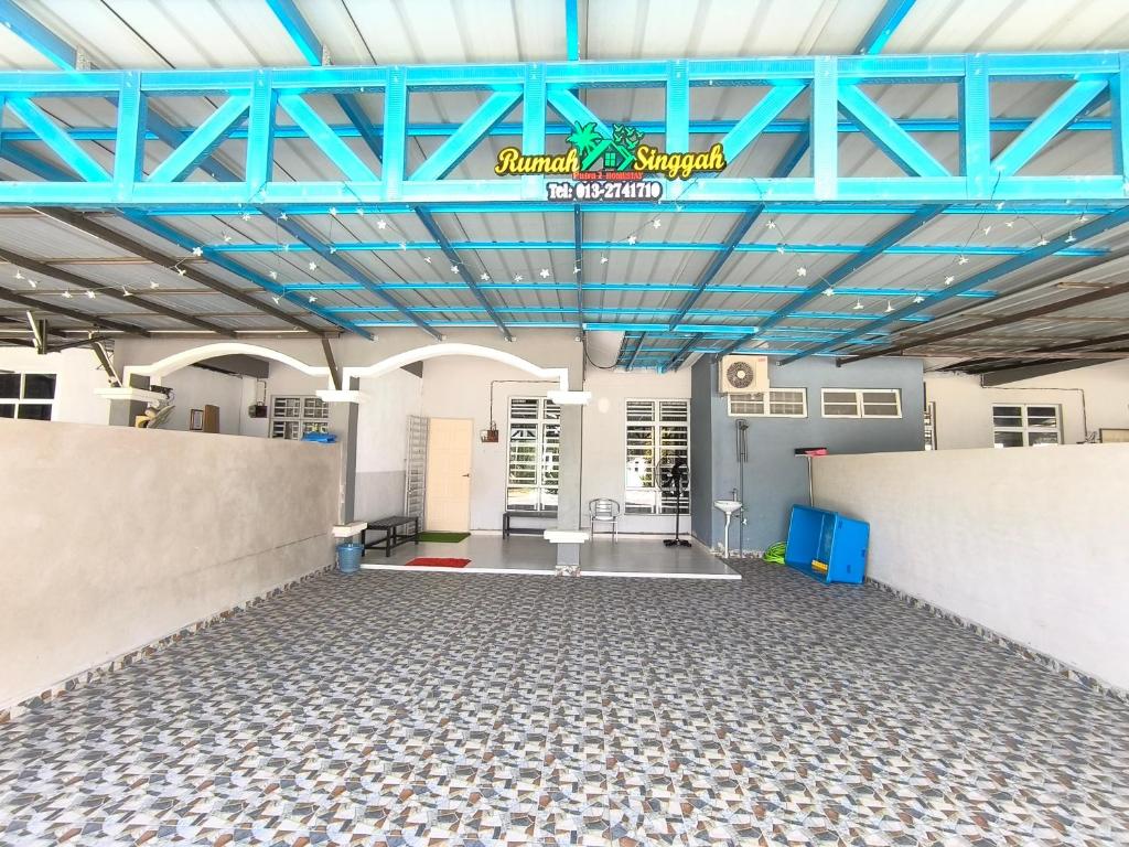 话毛生Putra 2 Homestay的一间大型客房,拥有蓝色的天花板和瓷砖地板。