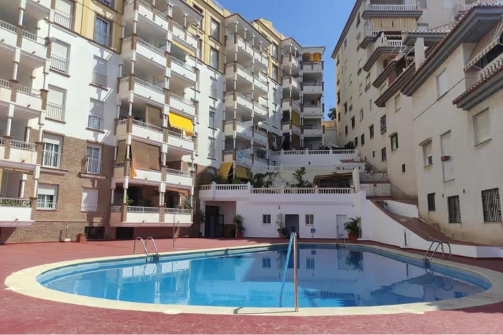 拉海瑞德拉"La Casita de Sal" cerca de la playa, con piscina comunitaria y wifi的公寓大楼前的庭院里设有一个大型游泳池