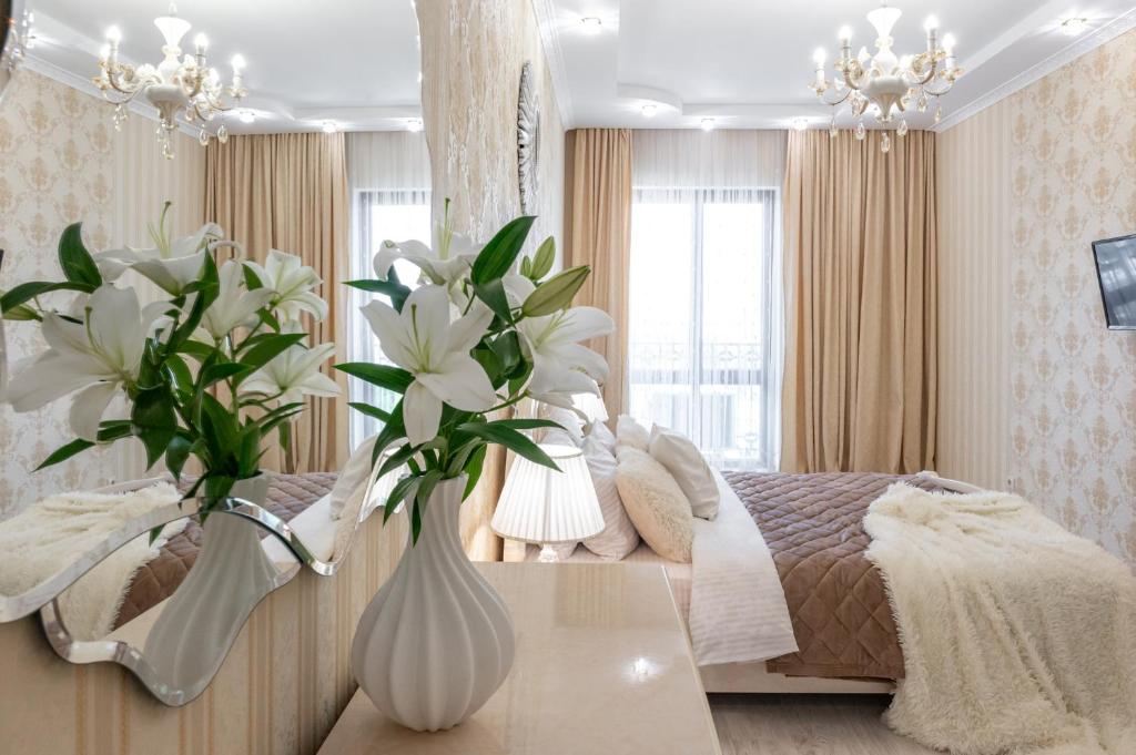 敖德萨Красивая квартира в ЦЕНТРЕ Одессы的一间卧室配有一张床和一张鲜花桌