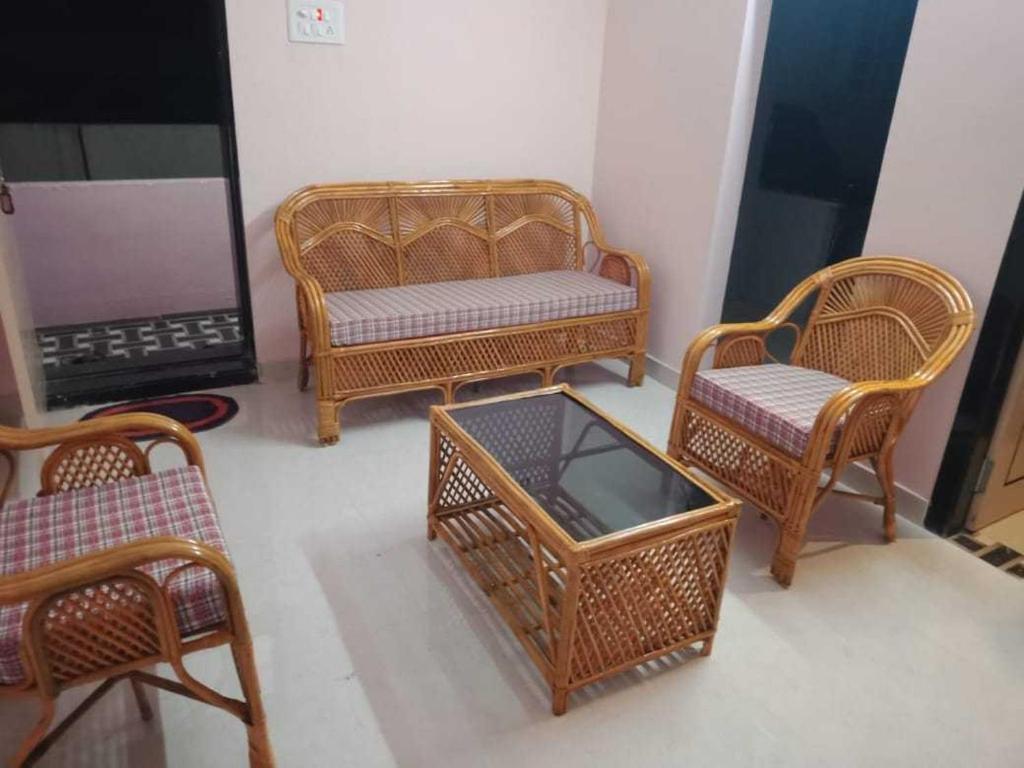 拉加蒙德里OYO HOME 81185 Srinivas Service Home的一组柳条椅和一张桌子