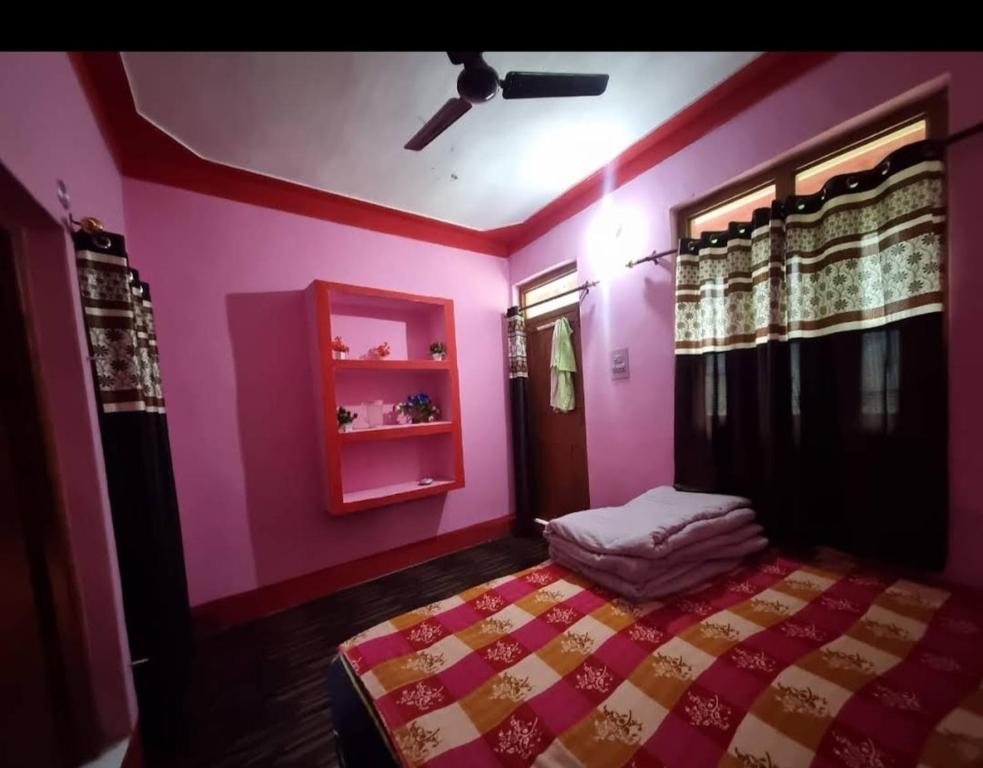 UkhimathKailash torisht loge的卧室设有粉红色的墙壁和一张床