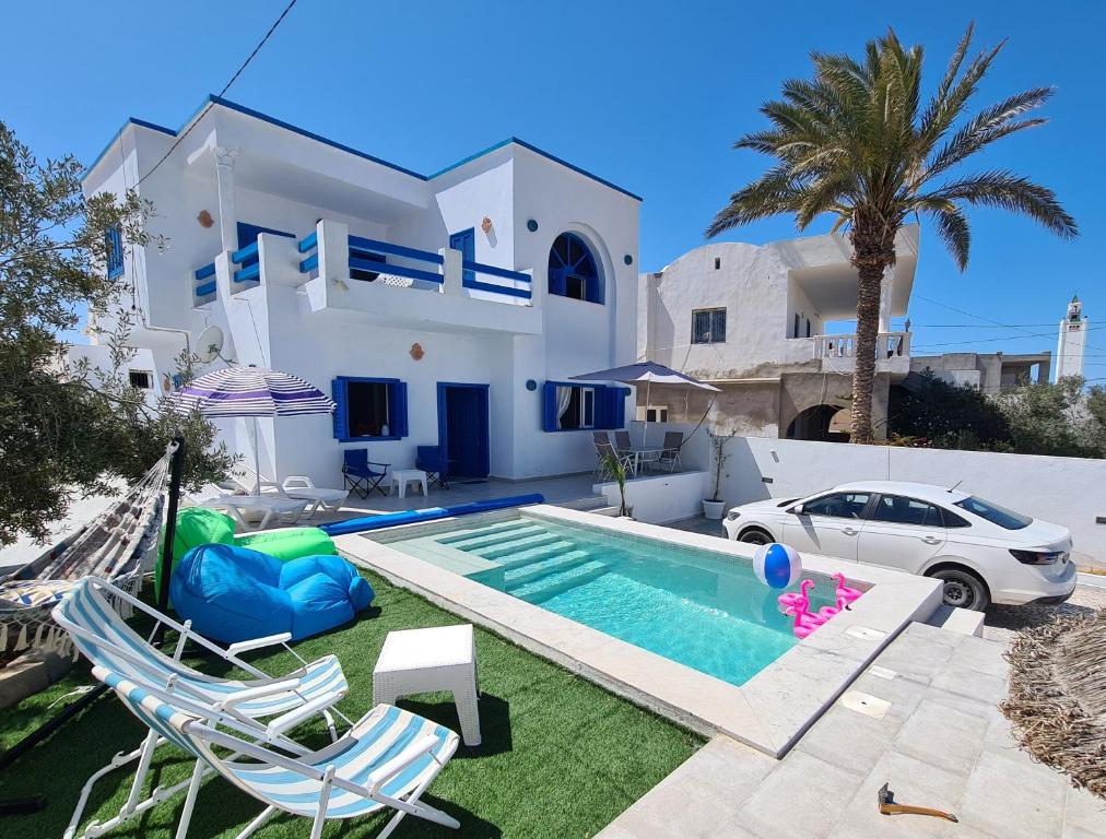 杰尔吉斯Villa Bleue plage Sonia的别墅前设有游泳池