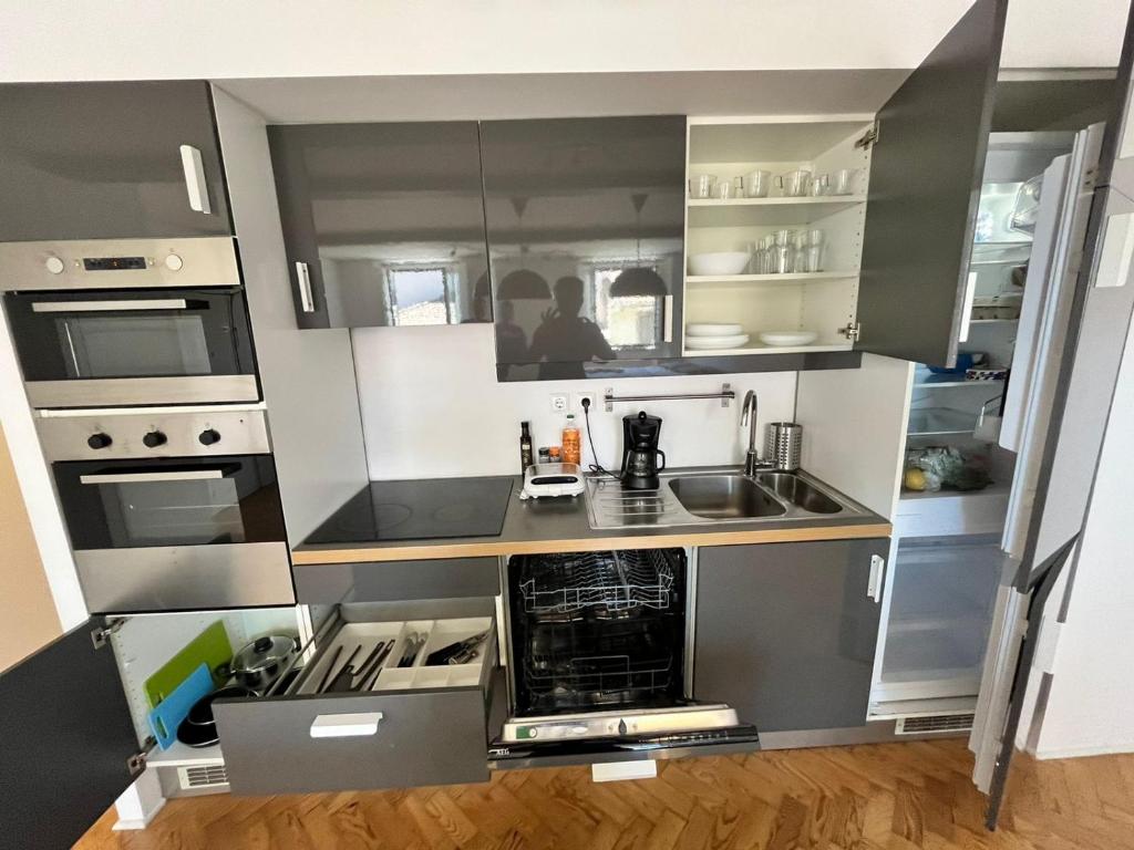 里斯本LISBON CENTRE BIG SUPERIOR FLAT的一间小厨房,配有灰色和白色的橱柜