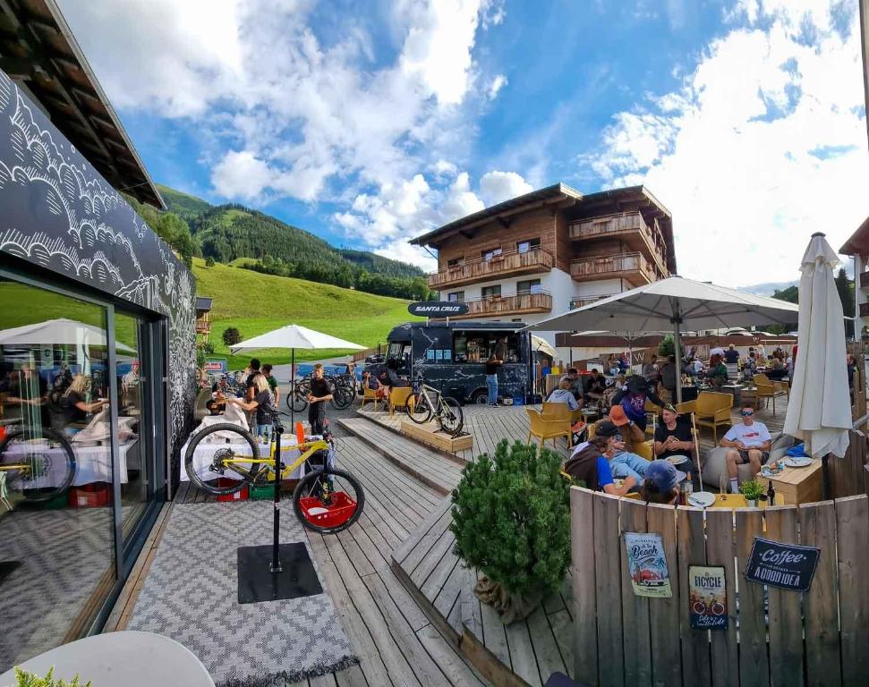 萨尔巴赫SKILL Mountain Lodge - Ski und Bike Hostel inklusive JOKER CARD的一群坐在大楼前桌旁的人