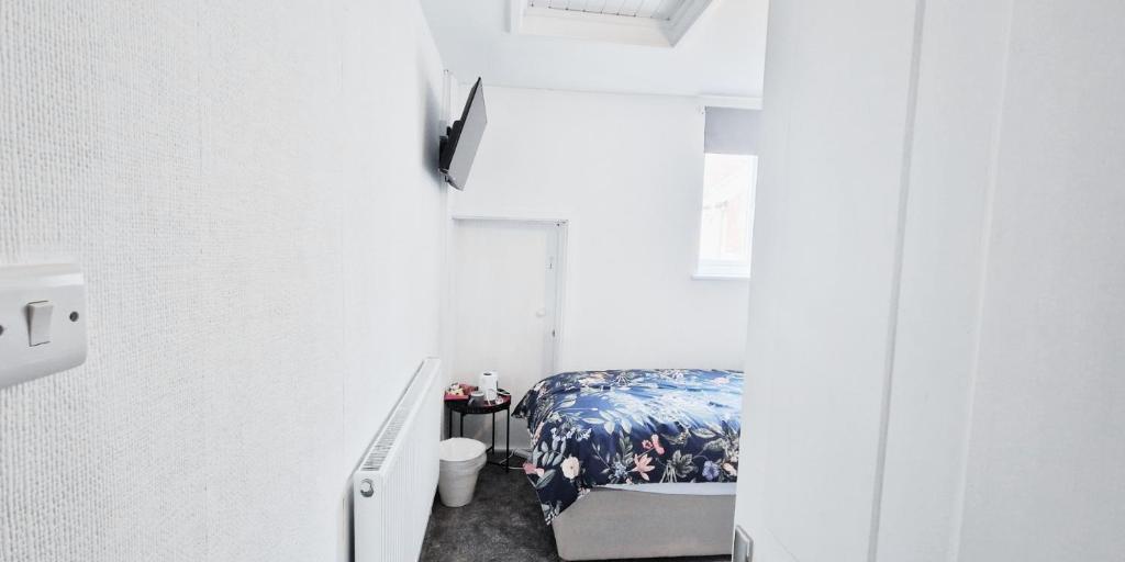诺丁汉Single Room in Modern House near Nottingham的一间小卧室,在白色的房间里配有一张床