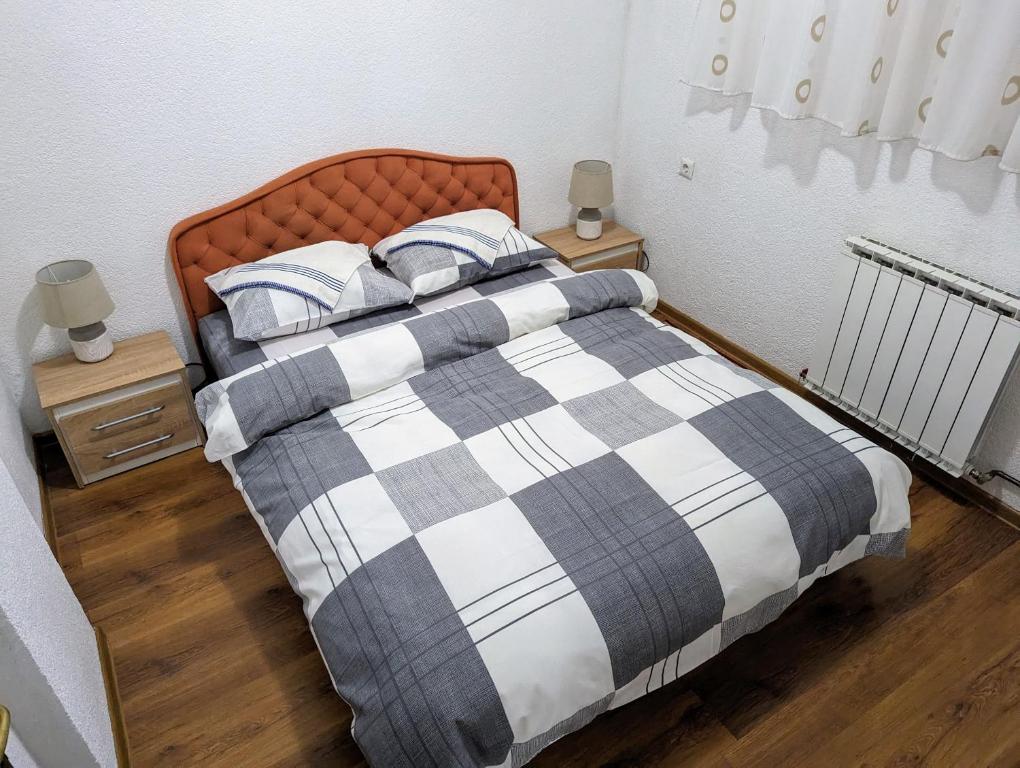 特拉夫尼克Apartment LAMI - Kalibunar, Travnik的一张带 ⁇ 子毯子和枕头的床