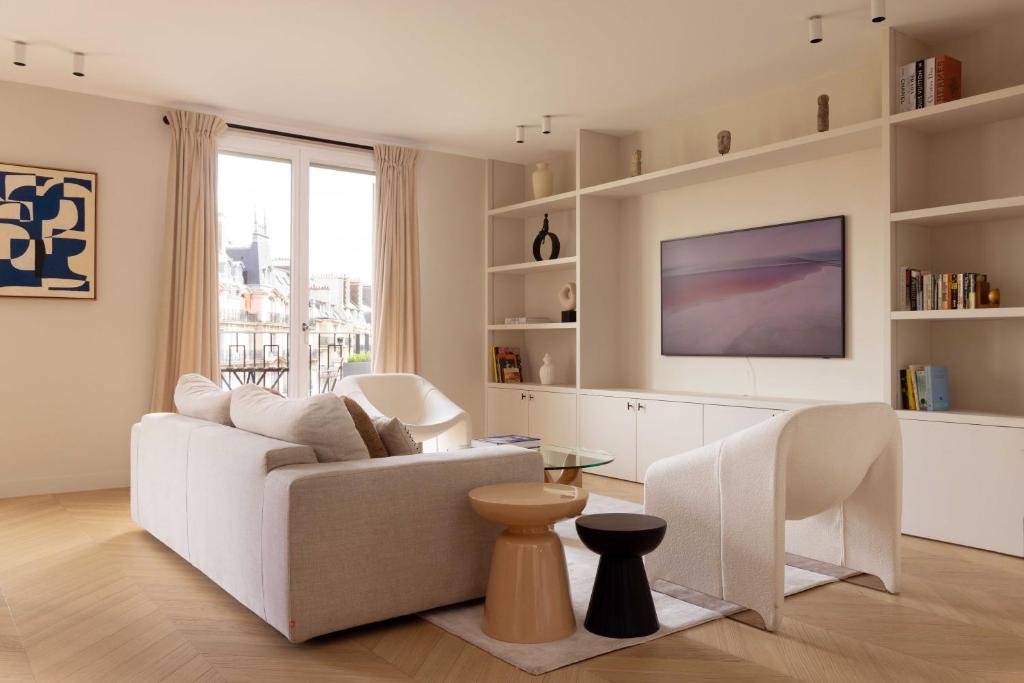 巴黎Luxurious Home in Triangle d'Or Eiffel Tower View的客厅配有白色沙发和电视