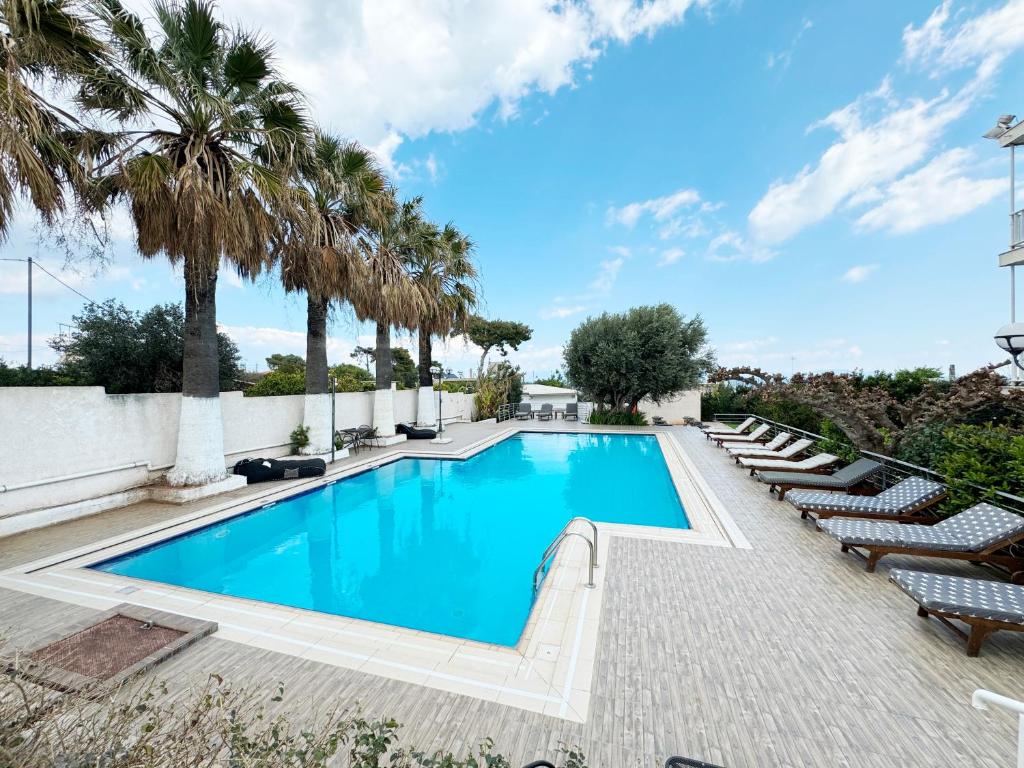 马蒂米尔托酒店的一个带躺椅的游泳池,棕榈树