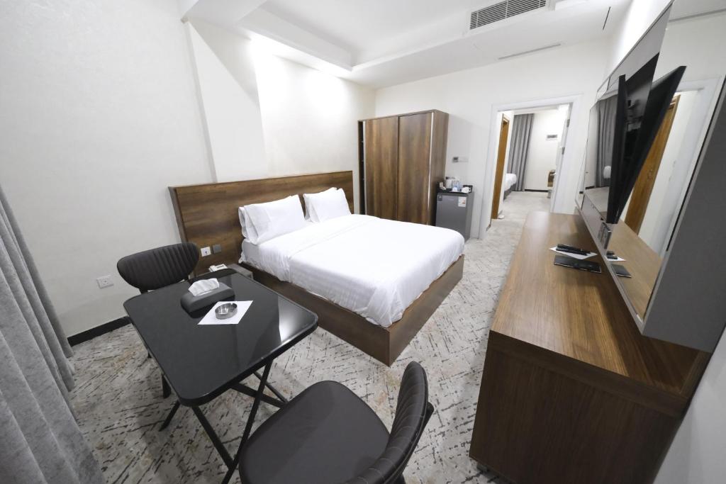 Al KarrādahAl jadriya Palace的酒店客房配有一张床、一张书桌和一台电视。