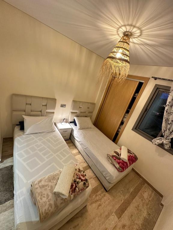卡萨布兰卡CHIC & COZY appartement très calme的一间卧室配有两张床和吊灯。