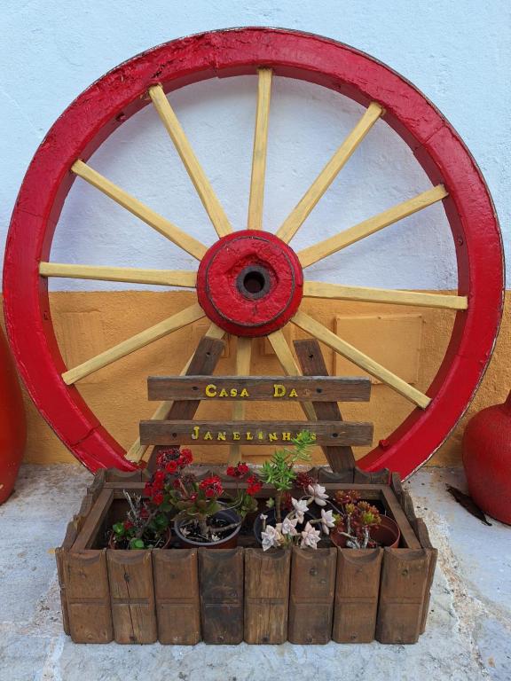 马夫拉Casa das Janelinhas - Cottage near Sintra, Mafra, Ericeira的种植园里木车轮与植物