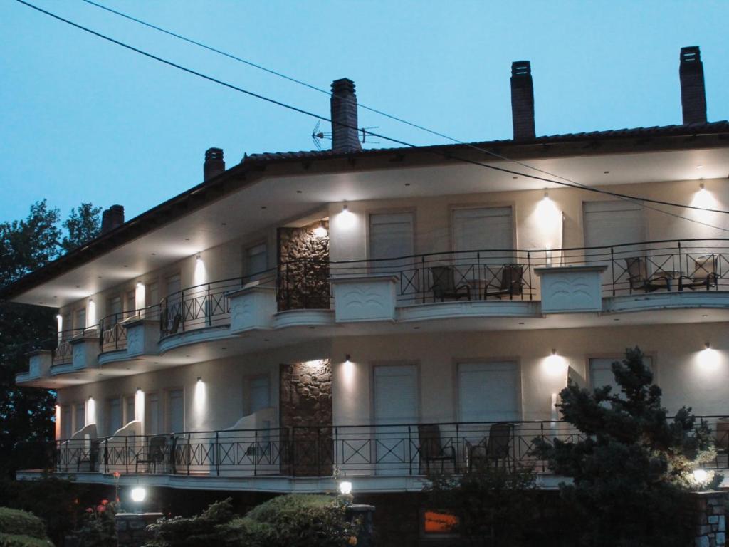 卡托劳塔翁Enastron Hotel的一座大型白色建筑,设有阳台和灯光