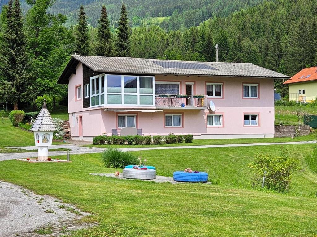 ArriachFerienwohnung Mangartblick的粉红色的房子,设有凉亭