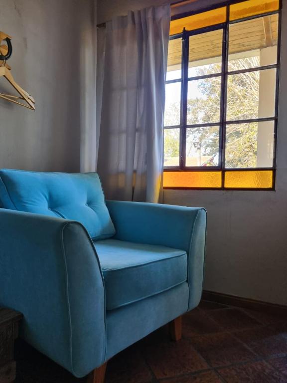 查斯科穆斯Tordillo B&B的客厅设有蓝色沙发,配有窗户