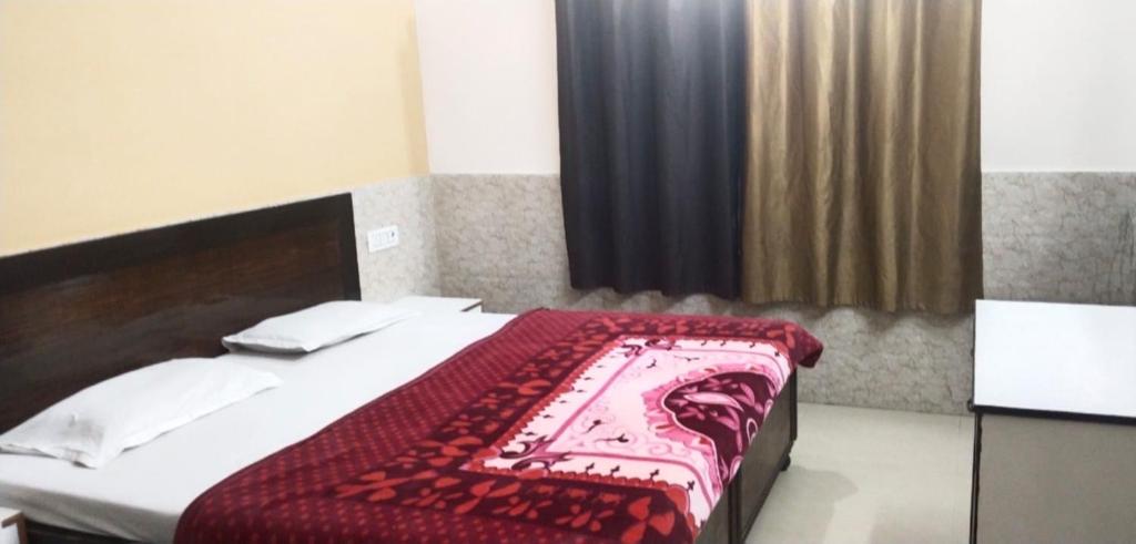 马图拉Goroomgo Kunj Residency Mathura Near Bus Stand - Parking Facility & Restrurant的一间卧室配有一张带红色毯子的床