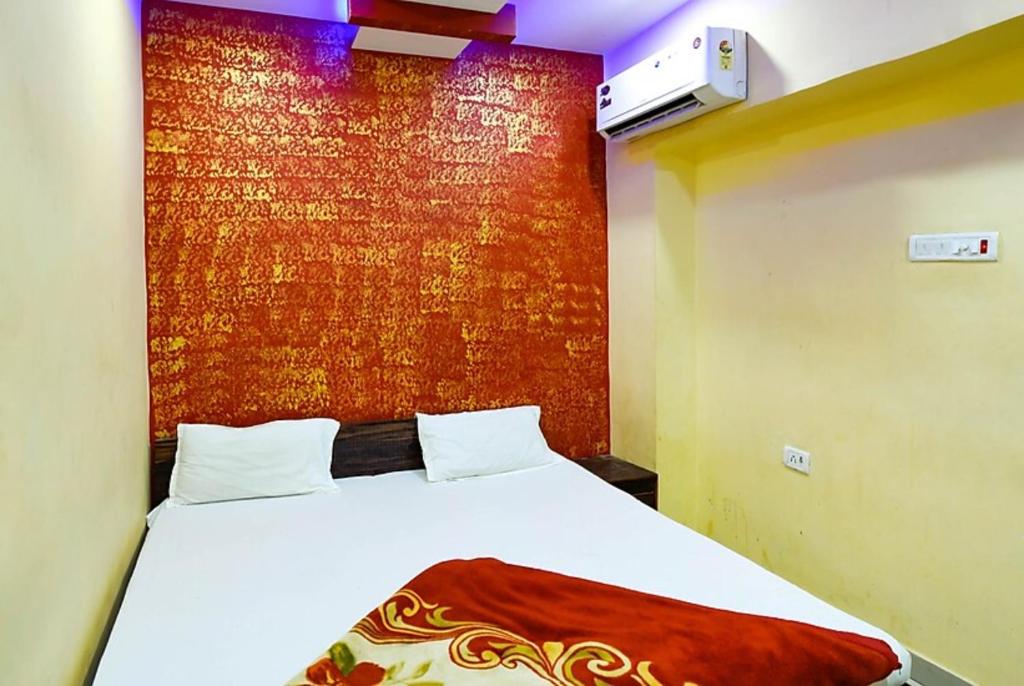 坎普尔Hotel Atithi Galaxy Kanpur Near Railway Station Kanpur - Wonderfull Stay with Family的一间卧室设有一张床和红色的墙壁