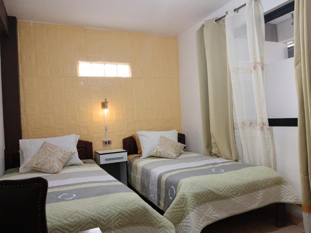 科恰班巴Casa Qura Qura的一间卧室设有两张床和窗户。