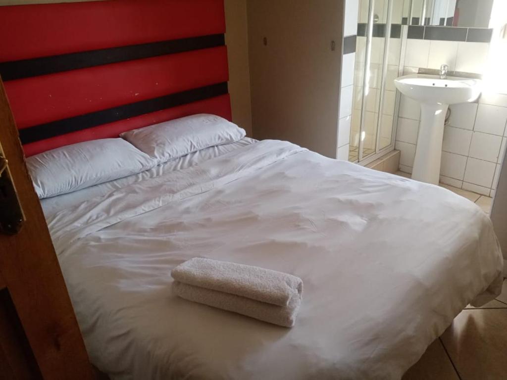比勒陀利亚Ebony Lounge Hotel and Event Center的床上有一条白色毛巾