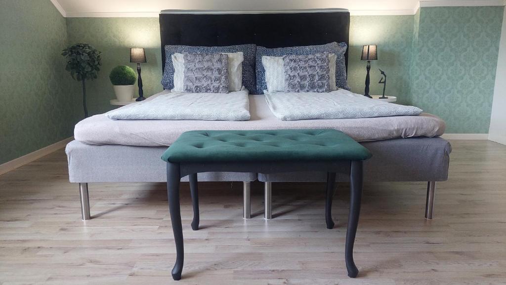 德拉门Øren apartment的一间卧室配有一张大床和绿色凳子