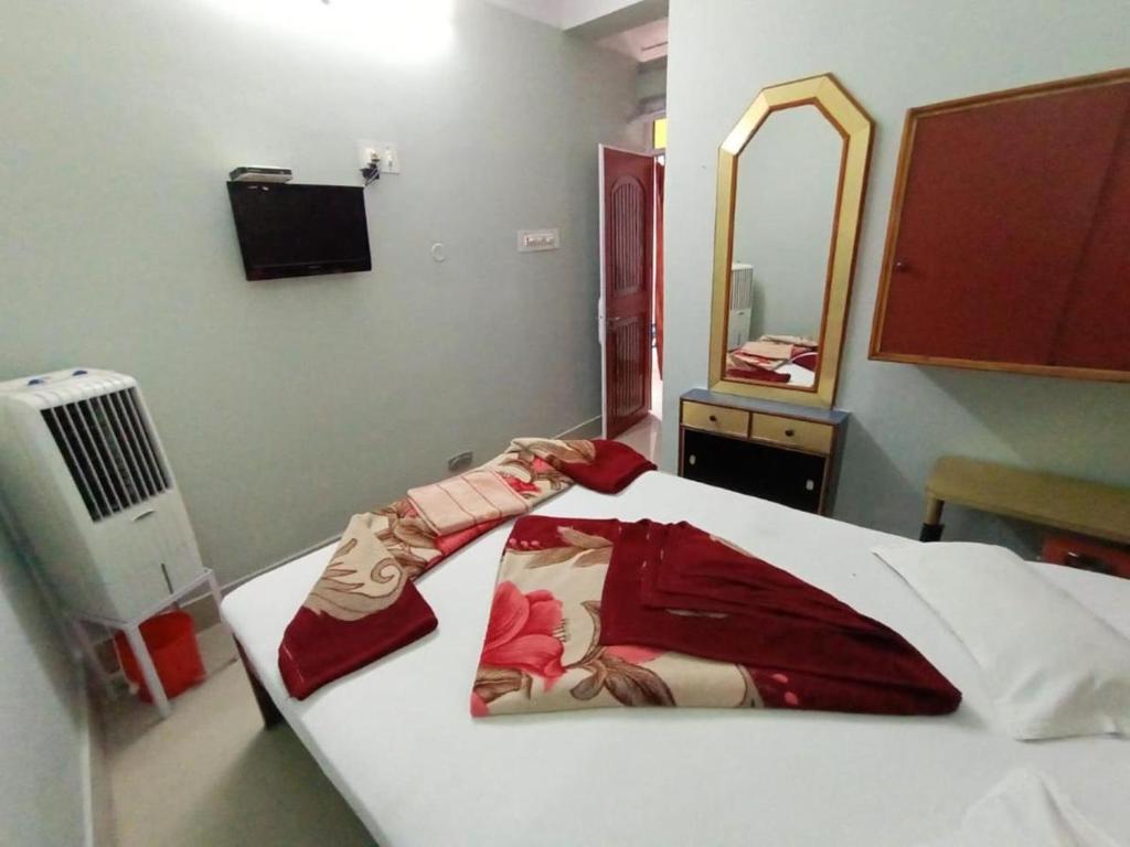 穆扎夫法尔普尔Hotel swapanlok, Couple Friendly Hotel的一间卧室配有一张带浴袍和镜子的床