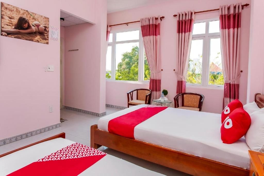 岘港Motel Tulip的一间卧室设有两张床和两个窗户。