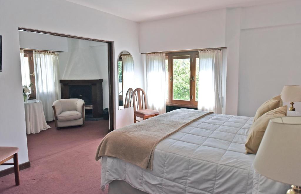 圣马丁德洛斯Hotel Caupolican by Visionnaire的一间卧室配有一张大床和镜子