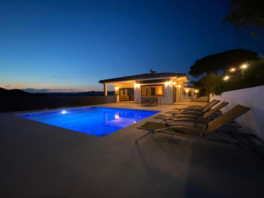 圣塔克里斯蒂纳阿鲁Villa Pirineus a beautiful villa with pool的夜间带游泳池的别墅