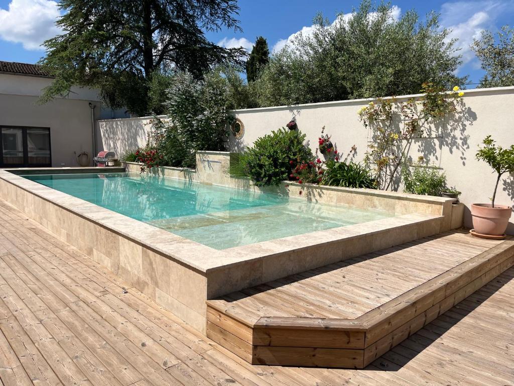 圣雷米普罗旺斯Les Logis de Cocagne的房屋旁带长凳的游泳池