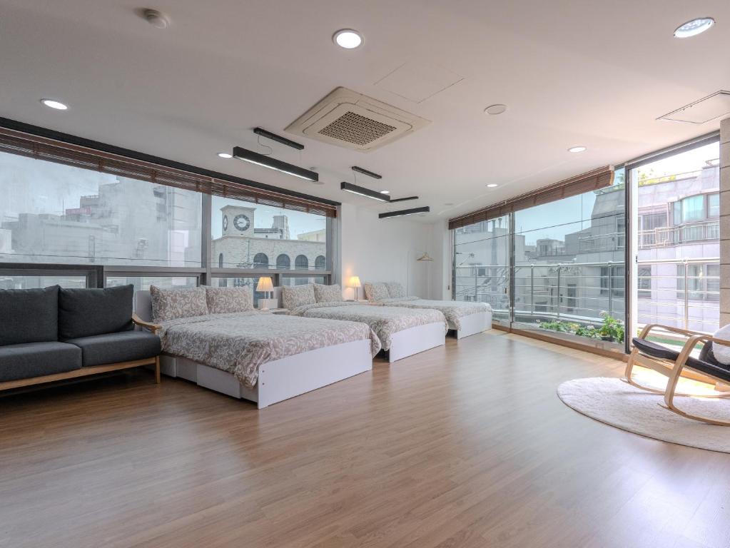 首尔Harmony Stay的一间卧室设有两张床、一张沙发和窗户。
