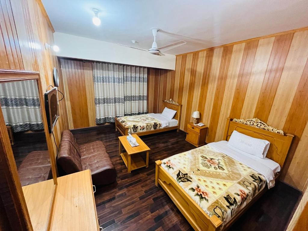 锡卡都Blue Sky Hotel & Restaurant的酒店客房,设有两张床和一张沙发