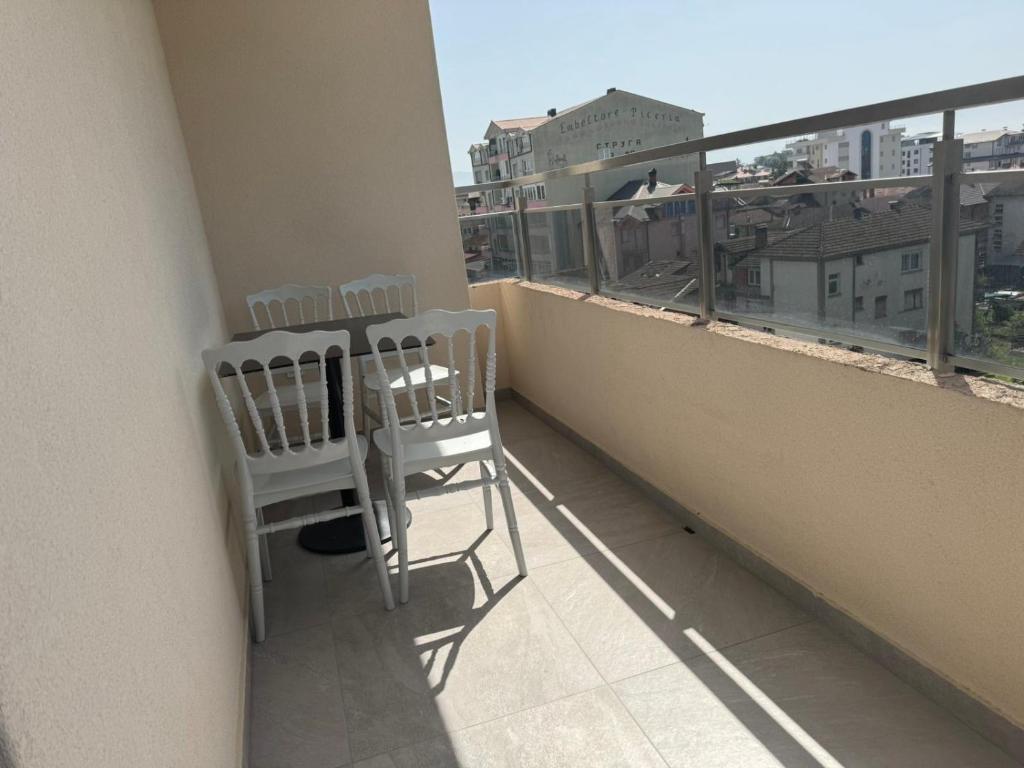 斯特鲁加Hotel Palace Struga的两把椅子坐在阳台上,眺望着城市