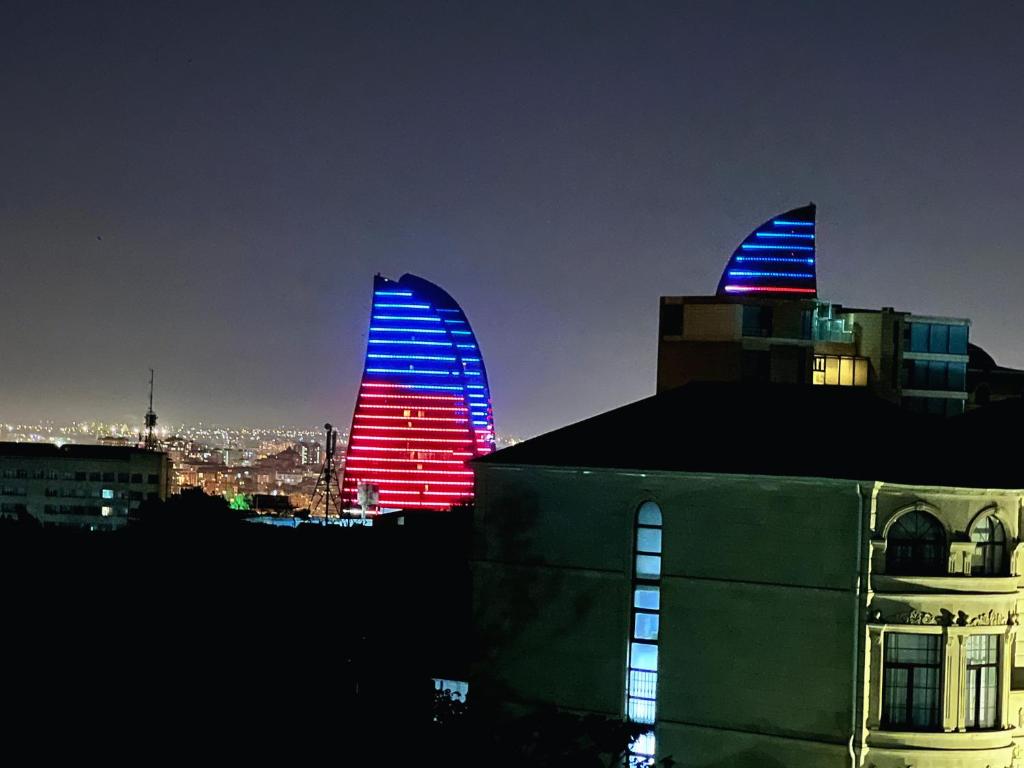 巴库Avrasya Hotel的两栋建筑用红色和蓝色点亮