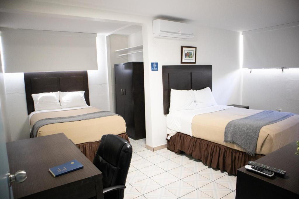 圣胡安柏林昆海滩酒店的酒店客房设有两张床和一张桌子。