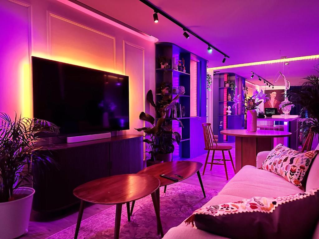 布拉迪斯拉发Ambient lounge with sundeck and free parking的客厅配有沙发和电视,拥有紫色照明