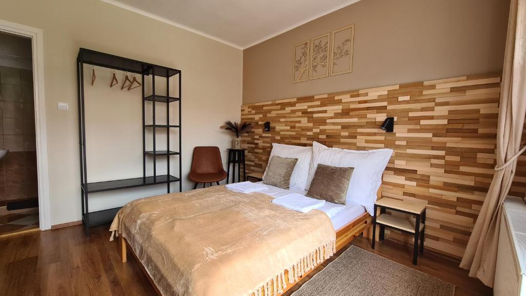 鲍科尼贝尔Bakonyi Kiscsillag的一间卧室设有一张床和木墙