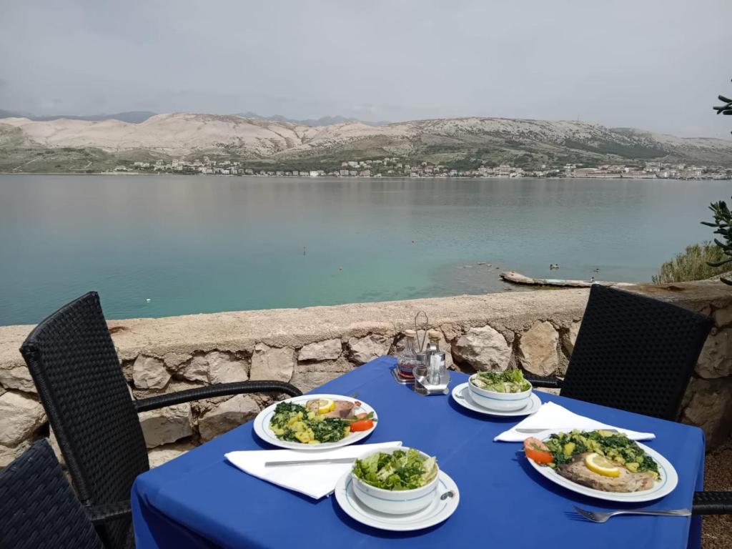 帕格毕塞尔酒店的湖畔的蓝色桌子,上面有盘子