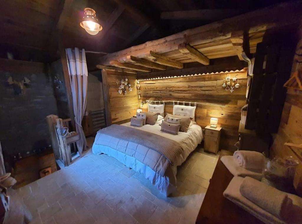 西克斯特Calme et sérénité 4 étoiles pour vos séjours VSD ou +的一间带一张大床的卧室,位于带木墙的房间