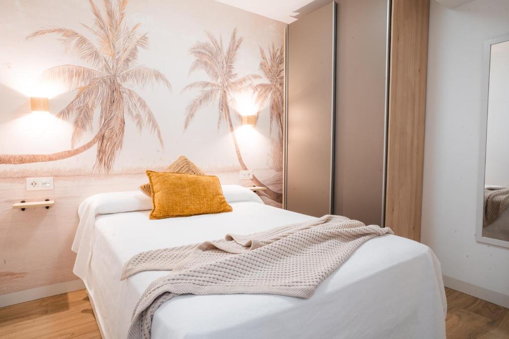 加鲁查Apartamento Boutique Beluga的卧室配有白色床和黄色枕头