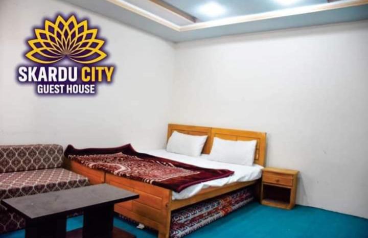 锡卡都Skardu city Guest house的一间卧室配有一张床和一张沙发