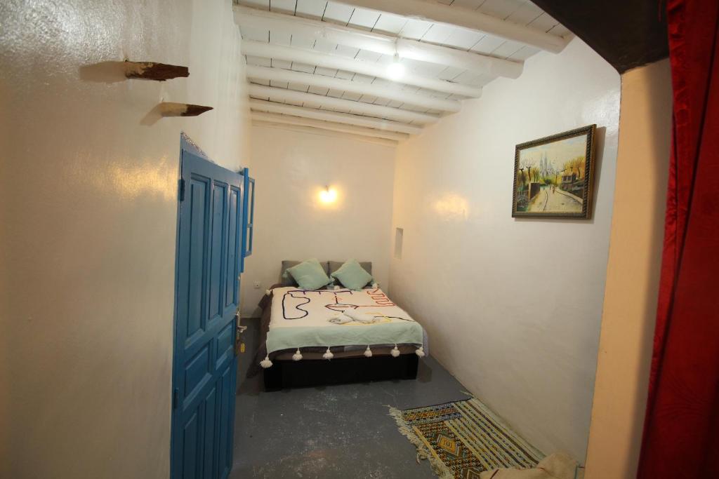 米勒福特ASARAG的小房间,配有一张带蓝色门的床