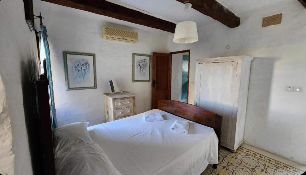 萨奈特Sannat Hills Farmhouse的卧室配有白色的床和镜子