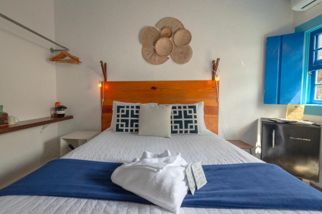 帕拉蒂Casas do Pátio Pousada & Bar的一间卧室配有一张带蓝白色床单的大床