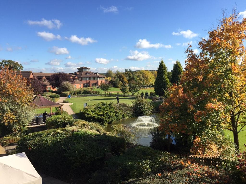 雷迪奇经典英国修道院高尔夫酒店&SPA的享有花园及池塘的景色