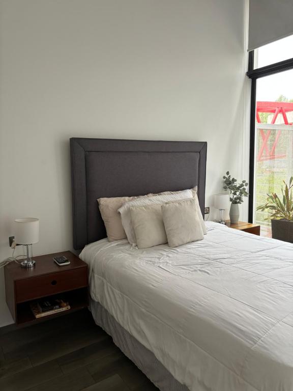 危地马拉Apartamento moderno 2 habitaciones y 2 banos area Cayala y Embajada USA CASH ONLY的卧室配有一张带两个枕头的大白色床