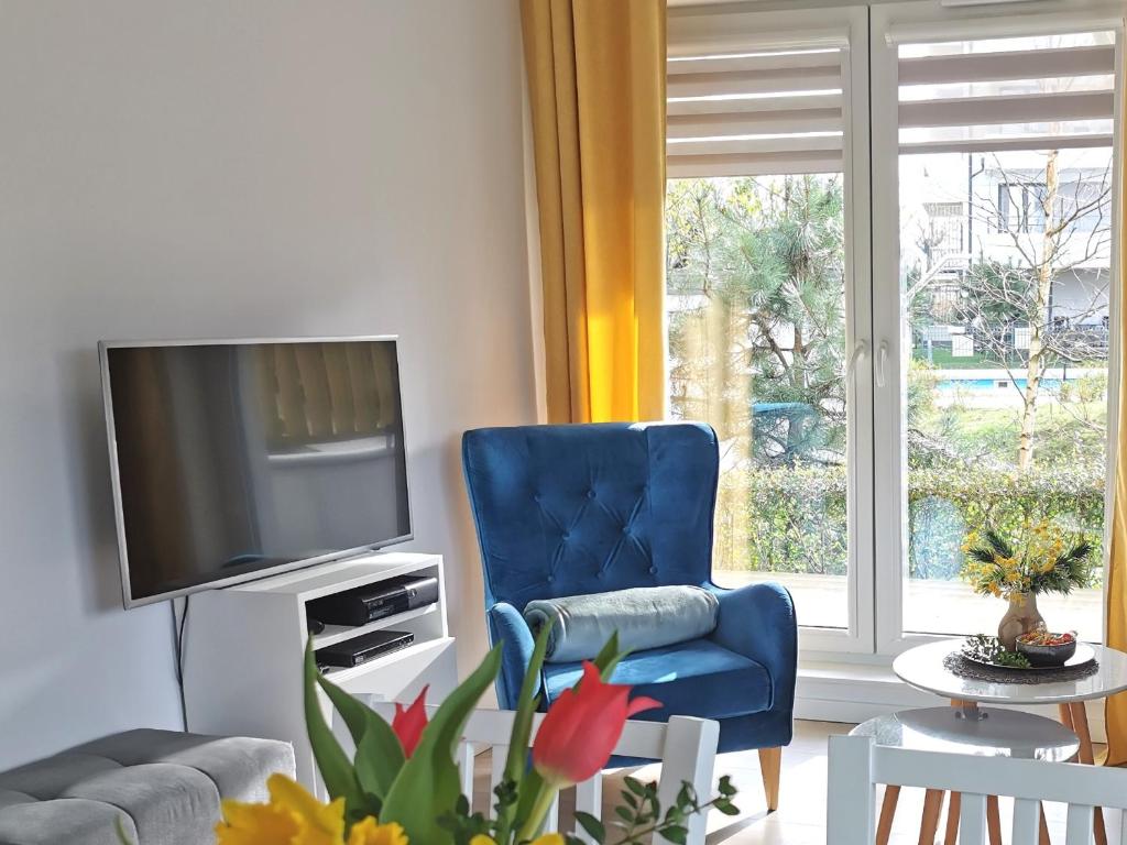 尤斯托尼莫斯基Apartamenty Wybrzeże Laguna的客厅配有蓝色椅子和电视