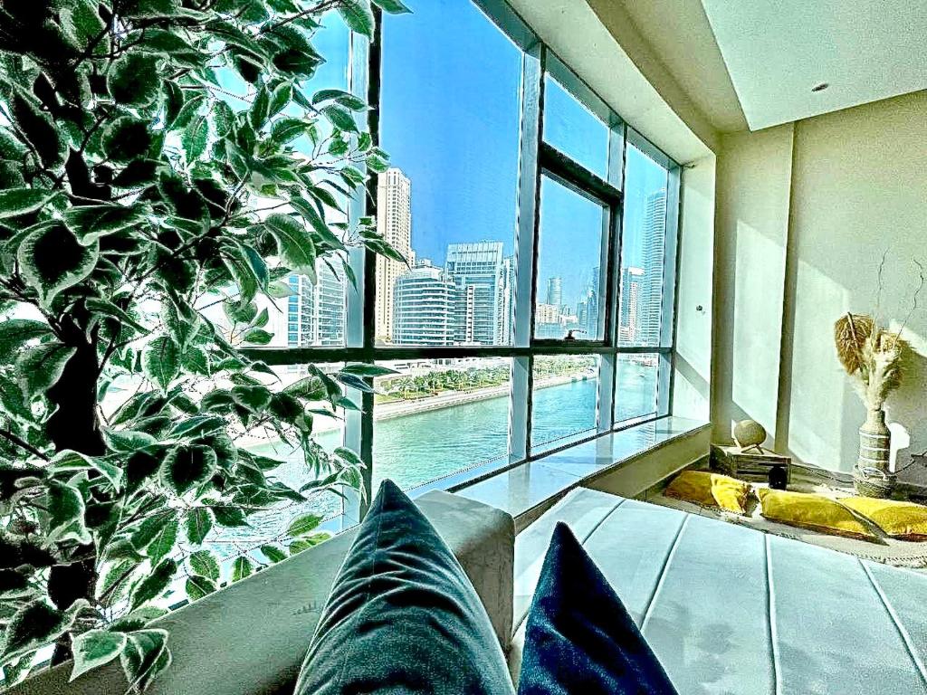 迪拜Wonderful two bed room with full marina view的客厅设有大窗户和大植物
